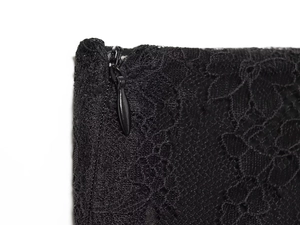 Detailed macro view of black floral lace fabric with a concealed side zipper closure