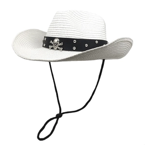 Detail of white woven straw cowboy hat with black leather belt and silver skull ornament