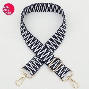 Detail of adjustable woven bag strap with blue and white geometric patterns and gold clips