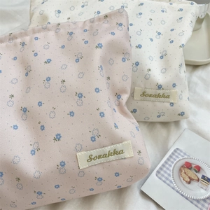 Detailed close-up of floral fabric texture and embroidered label on makeup organizers