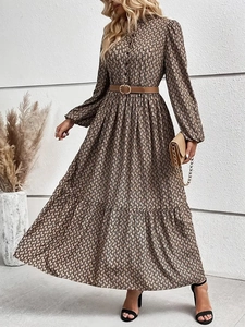 Elegant long-sleeved floral maxi dress in tan with a brown leather belt and lapel collar