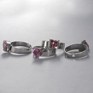 Detail view of pink heart gemstones set on four adjustable stainless steel rings
