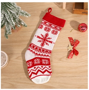 Close-up of red and white knitted Christmas stocking with snowflake patterns and hanging rope