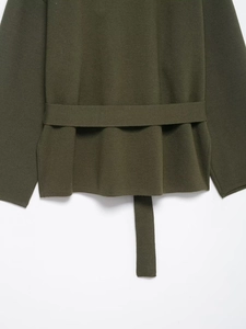 Detailansicht der dichten Strickstruktur und des passenden Gürtels an dieser dunkelgrünen Strickjacke