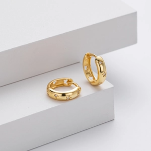Detailed macro view of S925 hallmark on gold plated star pattern hoop earrings
