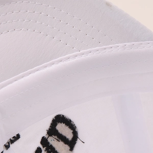 Detail of white cotton canvas kids baseball cap with black letter embroidery and stitching