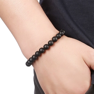 Close-up of matte black natural stone bead bracelet worn on wrist for a minimalist style