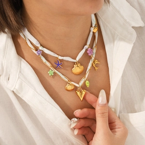 Collier multi-rangs doré avec foulard, pendentifs coquillage, étoile de mer et cœur sur mannequin