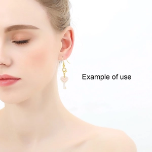 Detail view of heart and key earrings worn by a model showing the elegant drop design