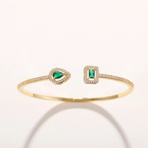 Detail of gold-plated brass cuff featuring green teardrop zircon and pavé crystals