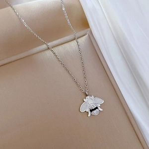 Vue détaillée du pendentif abeille argenté avec strass sur chaîne O dans un écrin