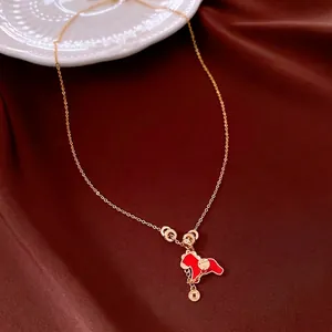 Collier cheval doré avec pendentif en émail rouge et breloques sur fond de soie
