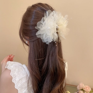 Detail of off-white mesh flower hair claw clip with pearls worn on long hair from behind