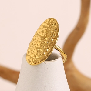 Close-up of hammered 18K gold plated oval ring surface with fine metallic textures