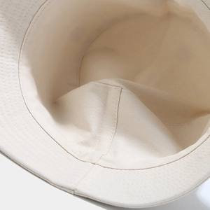 Détail de la couture intérieure et du tissu en coton sergé beige du chapeau