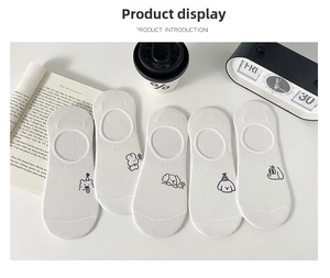 Detail view of five pairs of white cotton socks with cute cartoon animal embroidery