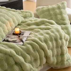 Detail of light green faux fur blanket and pillow with stylish wave texture design