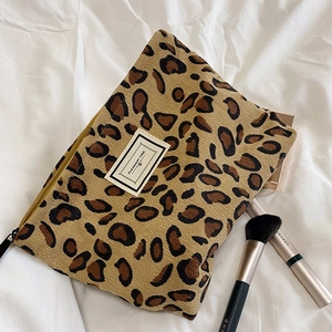 Detail of leopard print corduroy makeup bag with PLEASANT TIME label and zipper