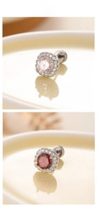 Détail de boucles d'oreilles halo rondes avec zircons roses et rouges en serti griffes
