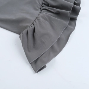 Gros plan détaillé des volants superposés gris anthracite sur une robe à manches longues