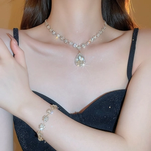 Detailed close-up of sparkling water-drop pendant necklace set on model neck