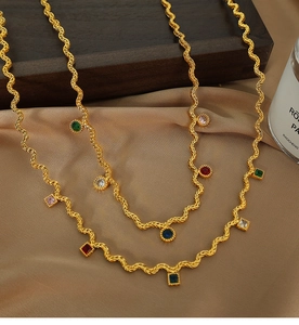 Detail of gold woven chain necklace with multi-colored cubic zirconia gemstones and silk
