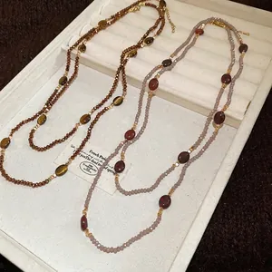 Ethnic style long beaded necklaces with tiger eye stones and golden spacers in a tray