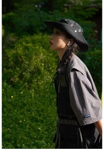 Detail view of a breathable dark gray fisherman hat with metal side eyelets for hiking