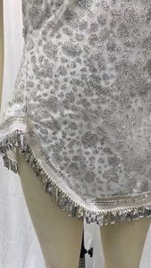 Détail de franges à paillettes argentées sur une robe de soirée à motif métallique chic