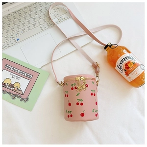 Detailed top view of pink cherry print bucket bag with golden flower zipper on white bedding