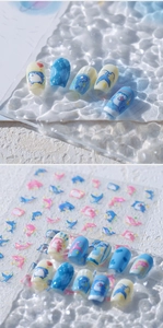Detail shot of ocean dolphin theme nail stickers with blue glitter finish