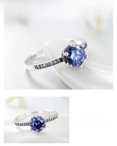 Close-up of S925 silver ring featuring a round blue zircon and pavé side stones