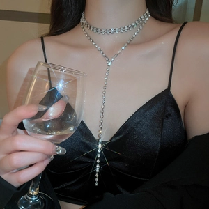 Dettaglio della collana a strati in argento con strass e frange su un abito da sera nero