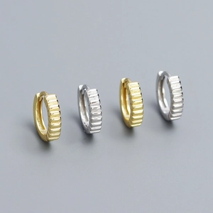 Detailed view of silver and gold textured hoop earrings with vertical stripe patterns