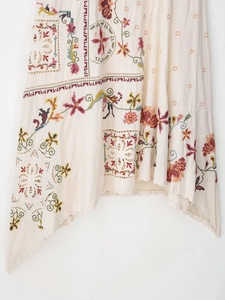 Detailed embroidery and openwork patterns on asymmetric bohemian dress fabric
