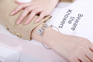 Silver mama heart charm bracelet worn with a stylish blazer for Mother's Day gift ideas