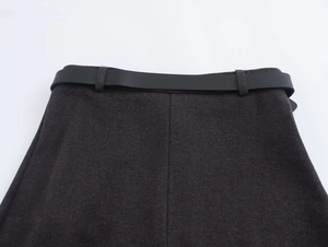 Detail of dark grey twill skirt waist with a minimalist black belt on white background