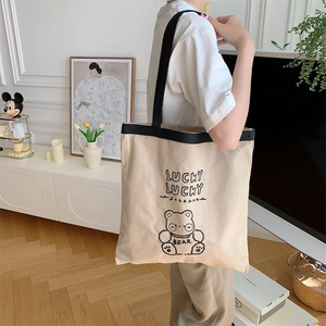 Large beige canvas tote bag with lucky bear print and black strap for daily use