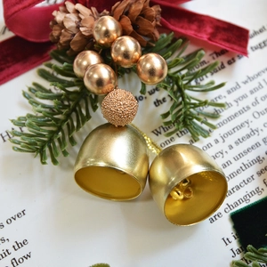 Christmas decoration with gold bells, red velvet bow, pine cones and needles on art paper