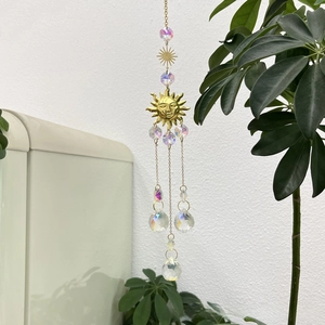 Detail of golden sun relief suncatcher with crystal prisms and rainbow maker hanging