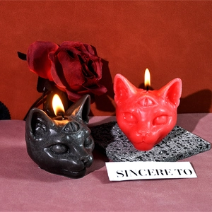 Three-eyed cat head scented candles in black and red for Gothic Halloween decor