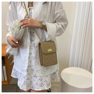 Detail of khaki quilted crossbody phone bag featuring a gold turn-lock and chain strap