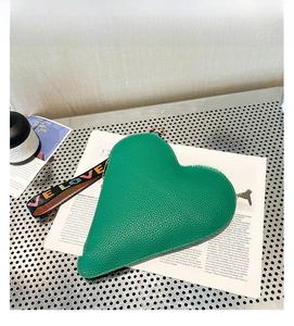 Détail macro du sac à main vert en forme de cœur avec cuir grainé et sangle Love