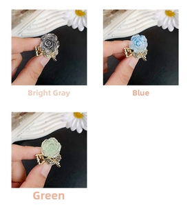 Close-up of glittery resin flower hair clips with sparkling rhinestones in three colors