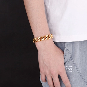 Close-up of a chunky gold Cuban link bracelet for men in street style on a male model