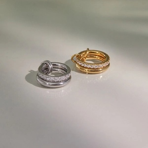 Close-up of interlocking gold and silver rings with pave crystals and polished finish