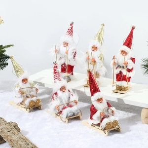 Set of six festive Santa Claus figurines with sleds and skis on a snowy holiday display