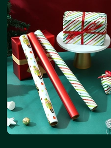 Three rolls of Christmas gift wrap featuring nutcracker prints and red festive patterns