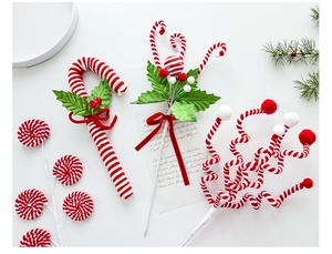 Detailed view of red and white twisted candy cane pick with green leaves and ribbon bow
