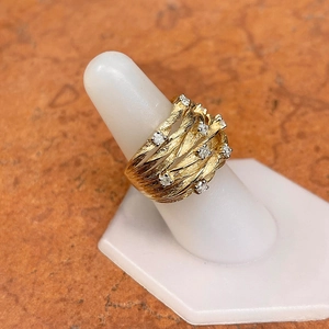 Macro shot of gold-plated woven vine ring with zircon stones on white stand